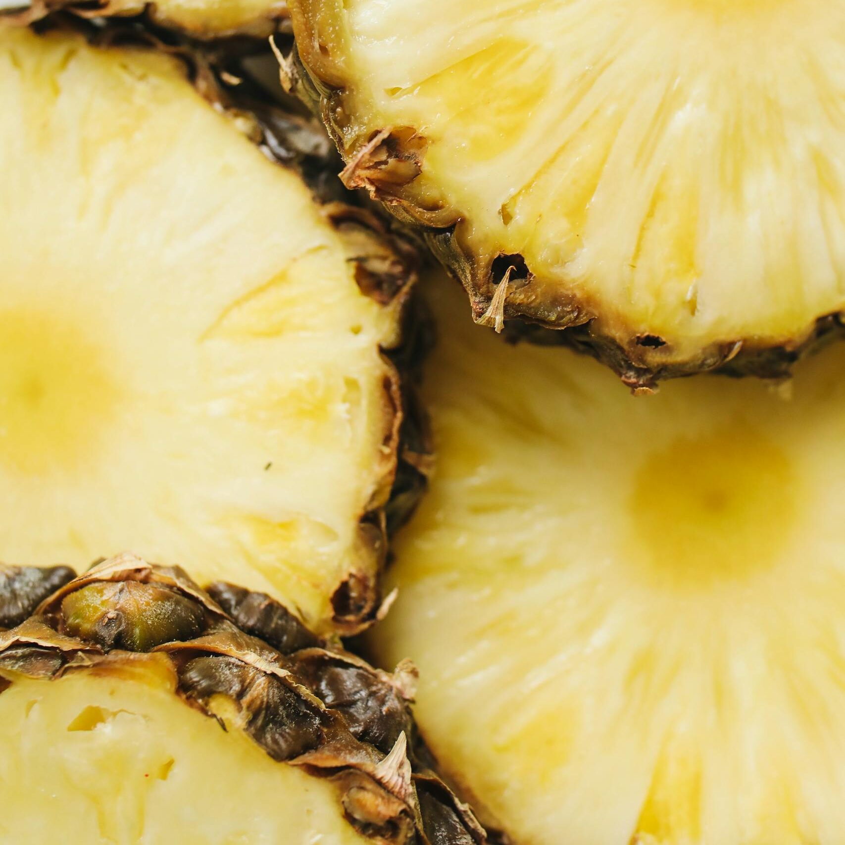 Vibrant close-up of fresh pineapple slices displaying juicy texture. Perfect for tropical themes and healthy food concepts.